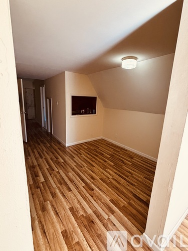 A room with wooden flooring and a light on the ceiling.