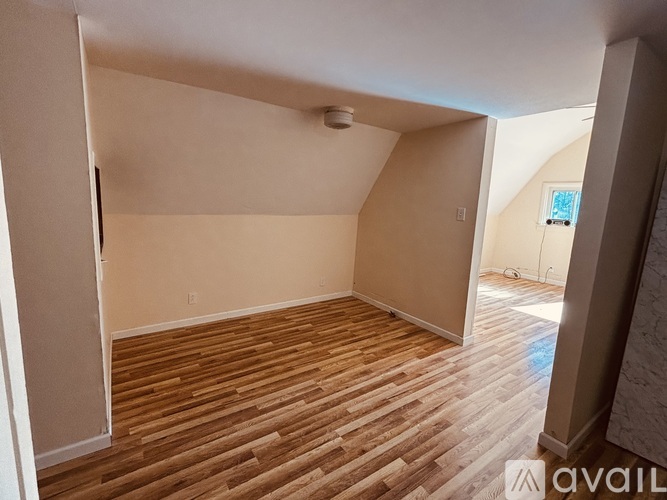 A room with wooden flooring and a skylight.