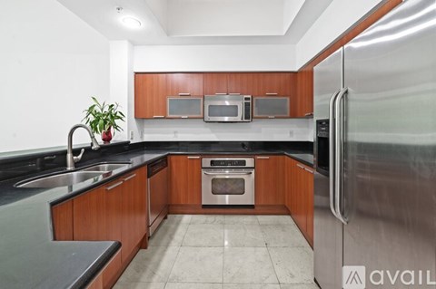 A kitchen with a stainless steel refrigerator, sink, and oven.
