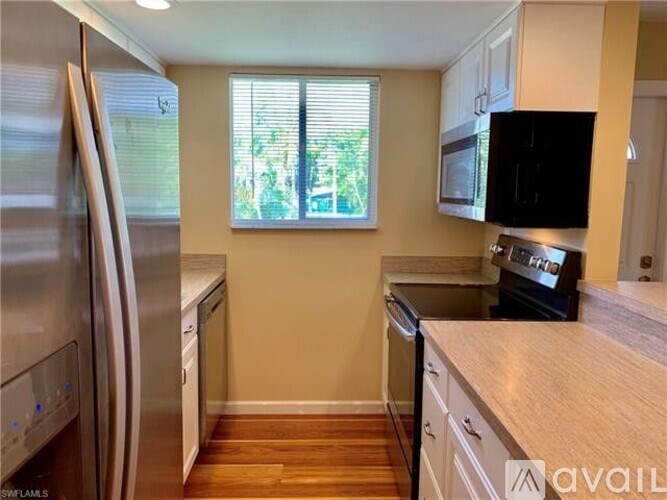 A kitchen with a stainless steel refrigerator and wooden countertops.