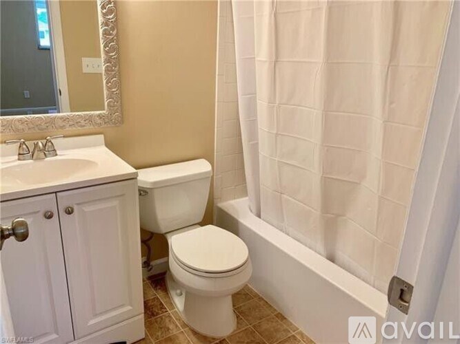 A bathroom with a toilet, sink, and shower curtain.