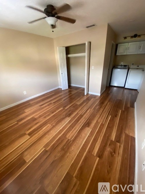 A room with wooden flooring and a ceiling fan.