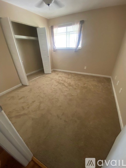 A room with a window and a fan on the ceiling.
