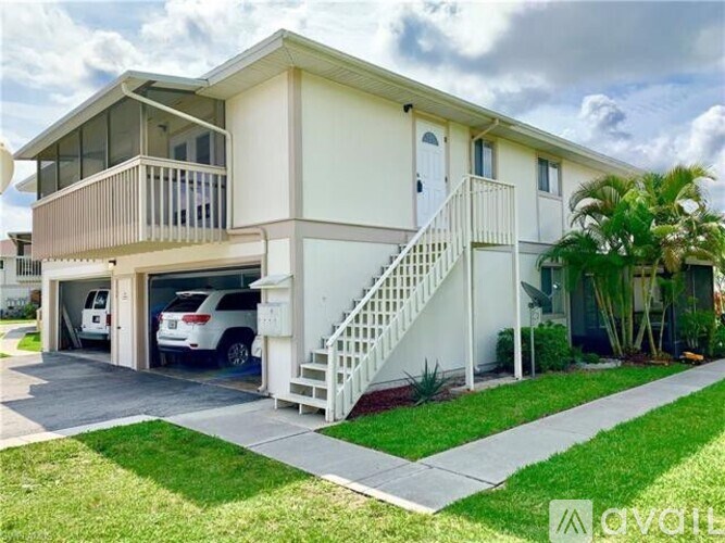 A two-story house with a balcony and a carport.