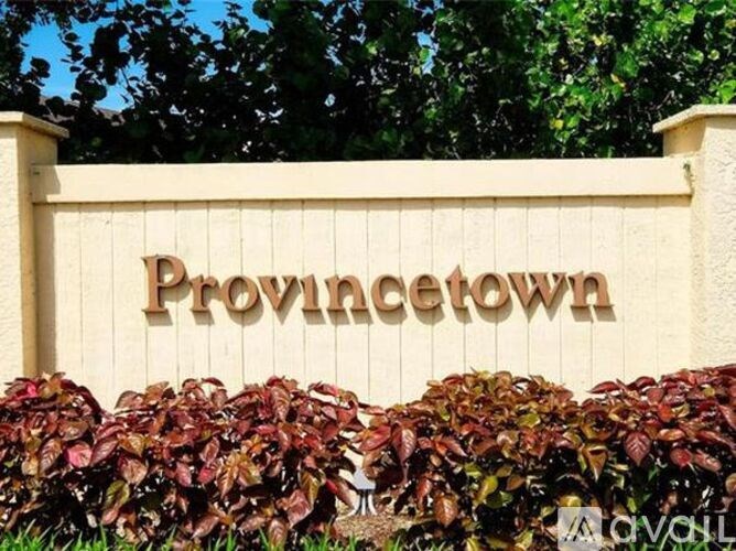 A sign that says "Provincetown" in front of some bushes.