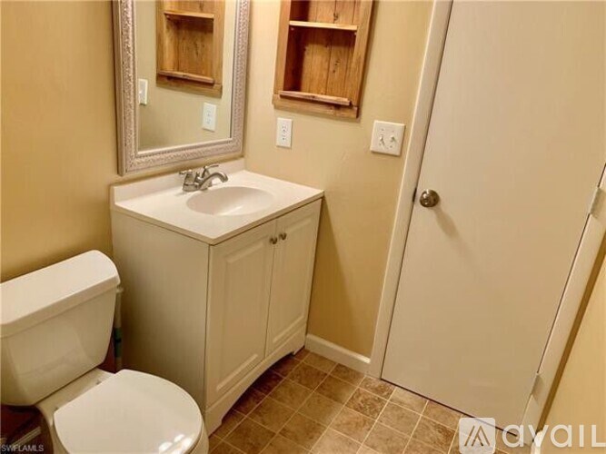 A bathroom with a toilet, sink, and medicine cabinet.