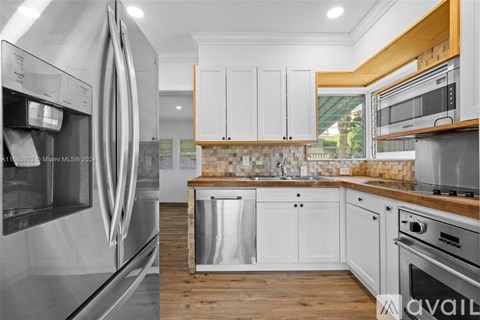 A modern kitchen with stainless steel appliances and wooden accents.