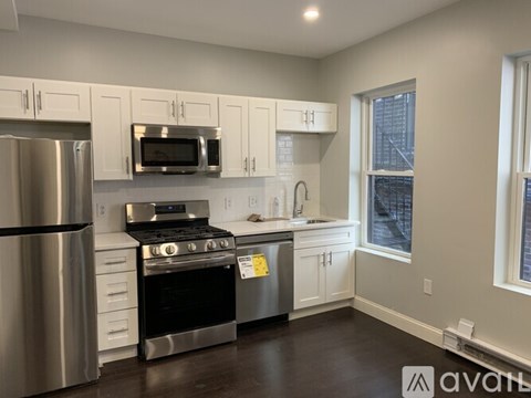 A kitchen with white cabinets and stainless steel appliances.