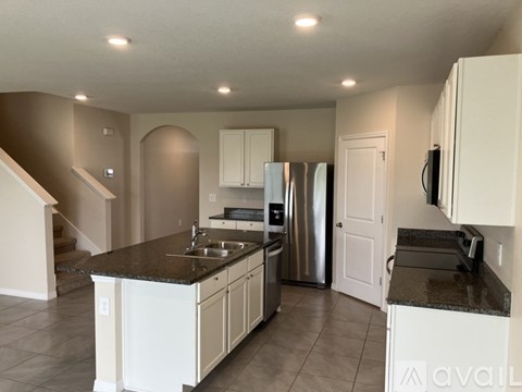 A kitchen with white cabinets and a granite countertop.