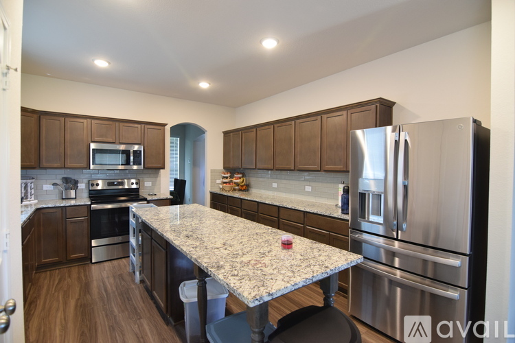 A kitchen with a granite countertop and stainless steel appliances.