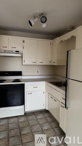 A kitchen with white appliances and cabinets.