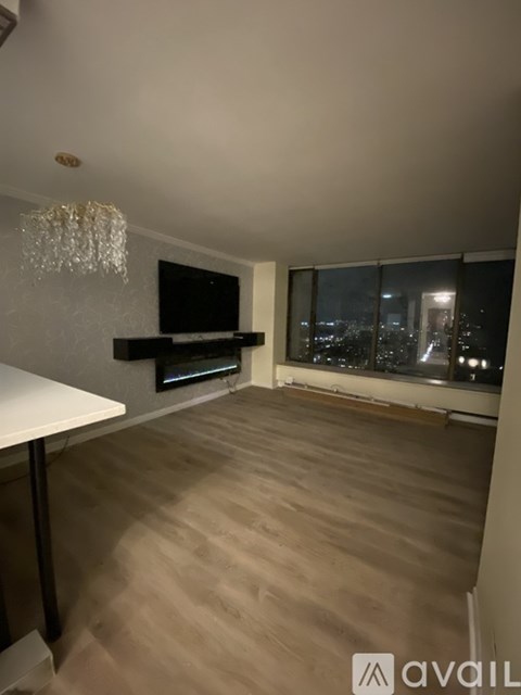 A living room with a television and a chandelier.
