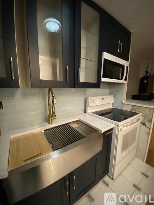 A modern kitchen with black cabinets and stainless steel appliances.