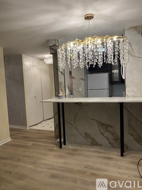 A room with a table and a chandelier hanging from the ceiling.