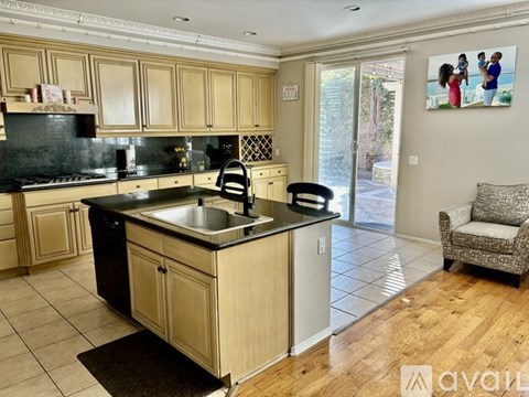 A kitchen with wooden cabinets and a black countertop.