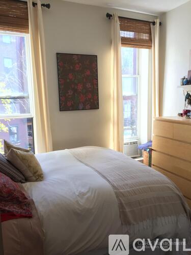 A bedroom with a large bed and a painting on the wall.