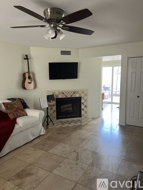 A living room with a fireplace and a television mounted above it.