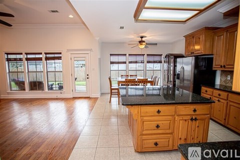 A kitchen with wooden cabinets and a black countertop.
