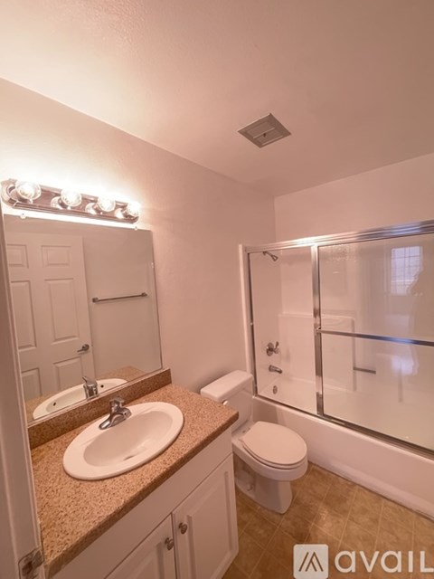 A bathroom with a sink, toilet, and mirror.