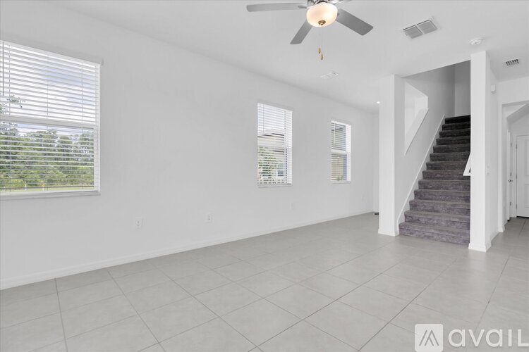 A spacious room with a staircase leading to another level.