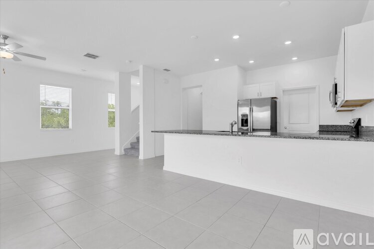 A spacious kitchen with white cabinets and a central island.