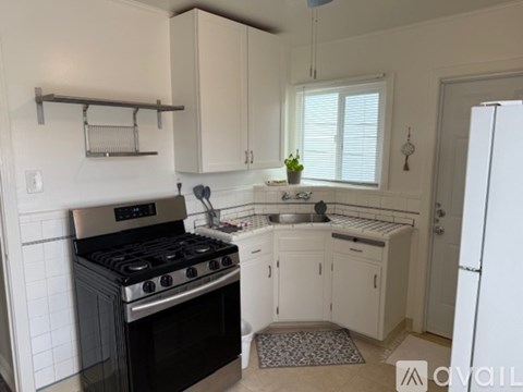 A kitchen with a black stove top oven and white cabinets.