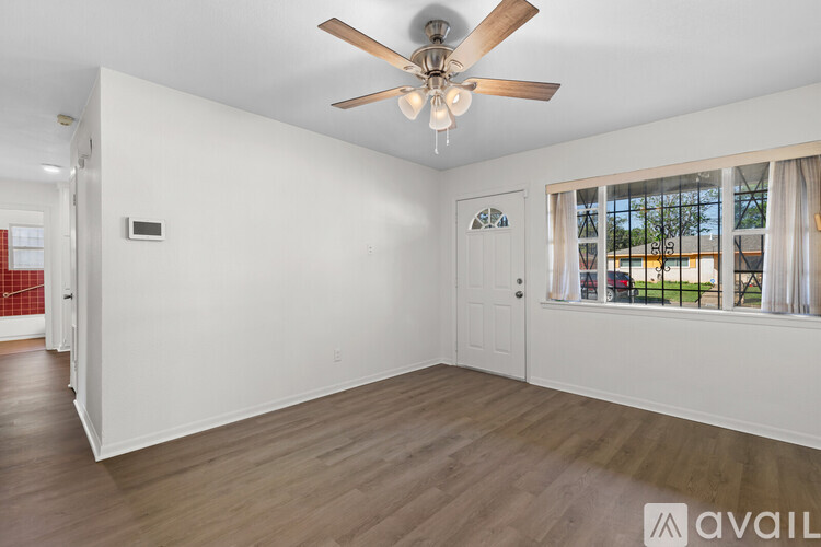 A room with a ceiling fan and a window with a view of the outside.
