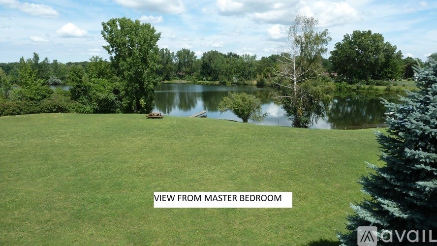 A serene landscape with a lake and trees from a master bedroom view.