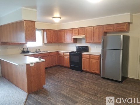 A kitchen with wooden cabinets and a black stove top oven.