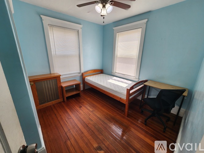 A room with blue walls and a ceiling fan.