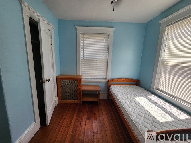 A bedroom with a bed, a ceiling fan, and a door.