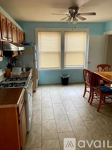 A kitchen with a stove top oven and a dining table.