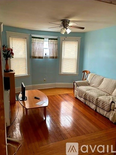 A living room with a couch, a coffee table, and a television.