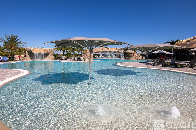 A large pool with a fountain in the middle and a waterfall in the background.