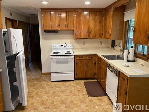 A kitchen with wooden cabinets and a white stove top oven.