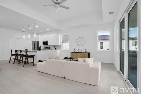 A modern living room with a white couch and a dining table.