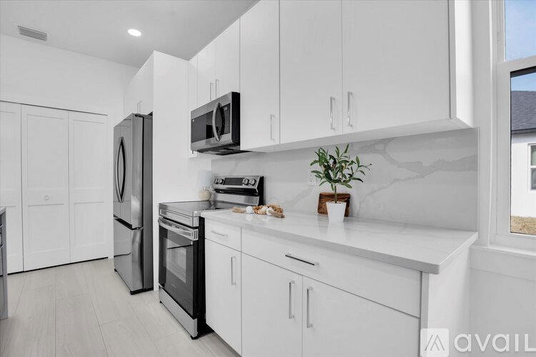 A modern kitchen with white cabinets and appliances.