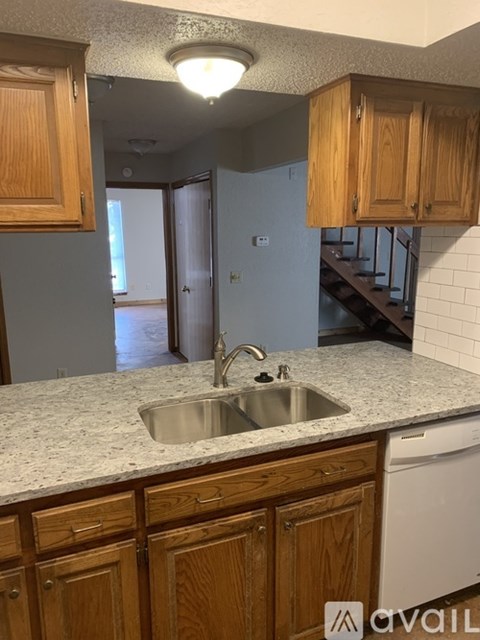 A kitchen with wooden cabinets and a granite countertop.