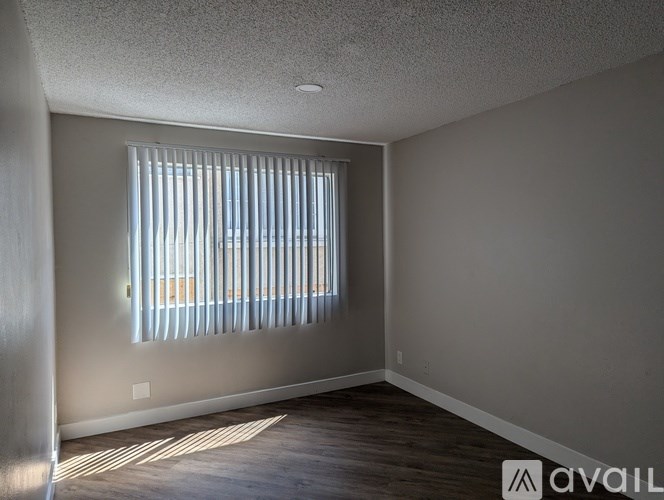 A room with a window covered by vertical blinds.