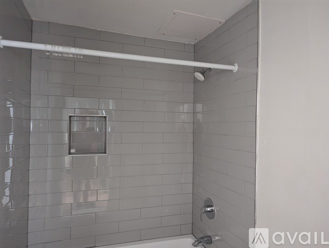 A bathroom with a glass shower door and a white shower head.