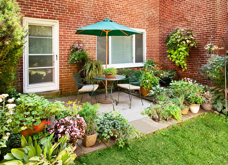 a backyard patio with a table and umbrella