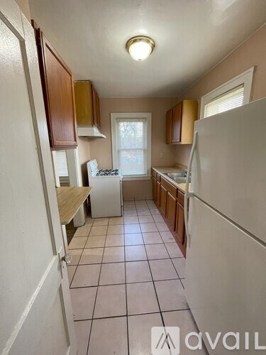 A kitchen with white appliances and wooden cabinets.