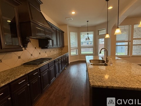 A kitchen with dark wood cabinets and granite countertops.