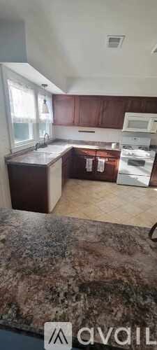 A kitchen with brown cabinets and a granite countertop.