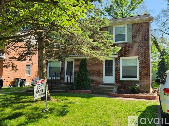 A house is for rent with a sign in front of it.
