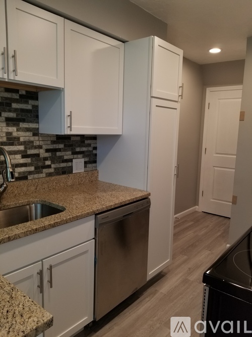 A kitchen with granite countertops and white cabinets.