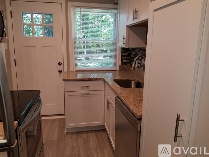 A kitchen with white appliances and cabinets.