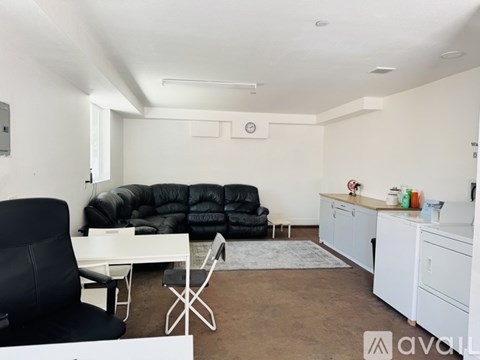A living room with a black chair and a black sofa.