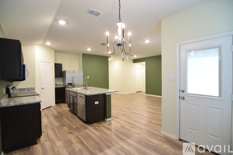 A kitchen with green walls and a wooden floor.