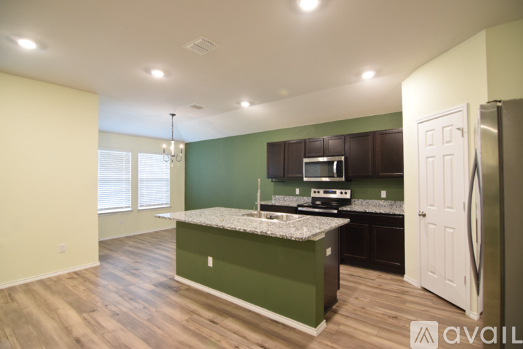 A kitchen with green cabinets and a white fridge.